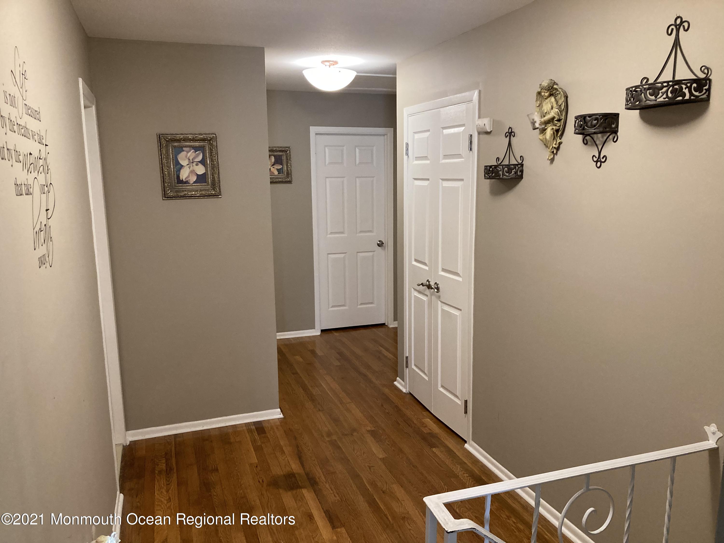8 Tudor Road Freehold, NJ 07728 - Photo 24 of 46 a view of hallway with stairs and wooden floor