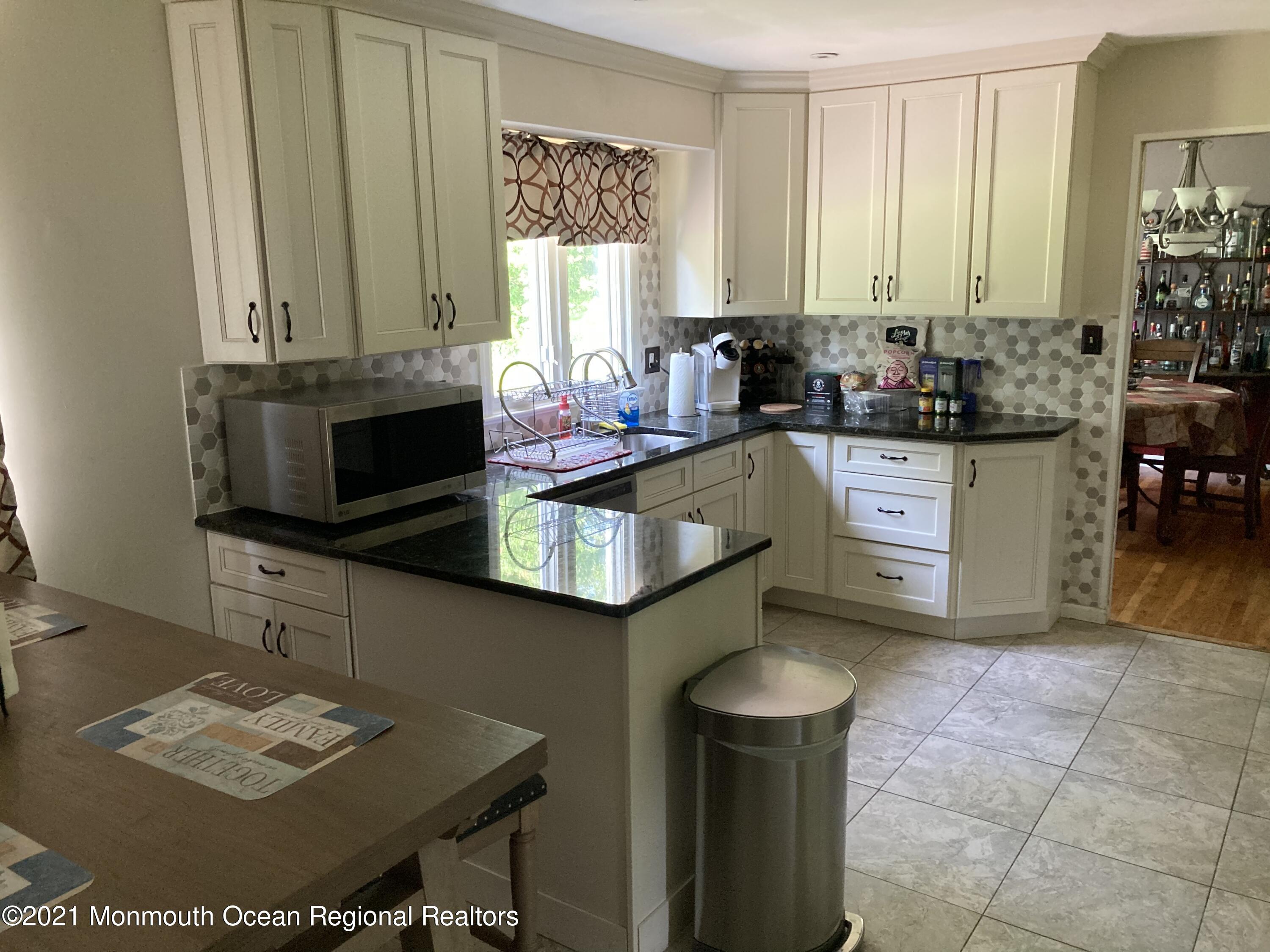 8 Tudor Road Freehold, NJ 07728 - Photo 7 of 46 a kitchen with stainless steel appliances granite countertop a stove a sink and a microwave