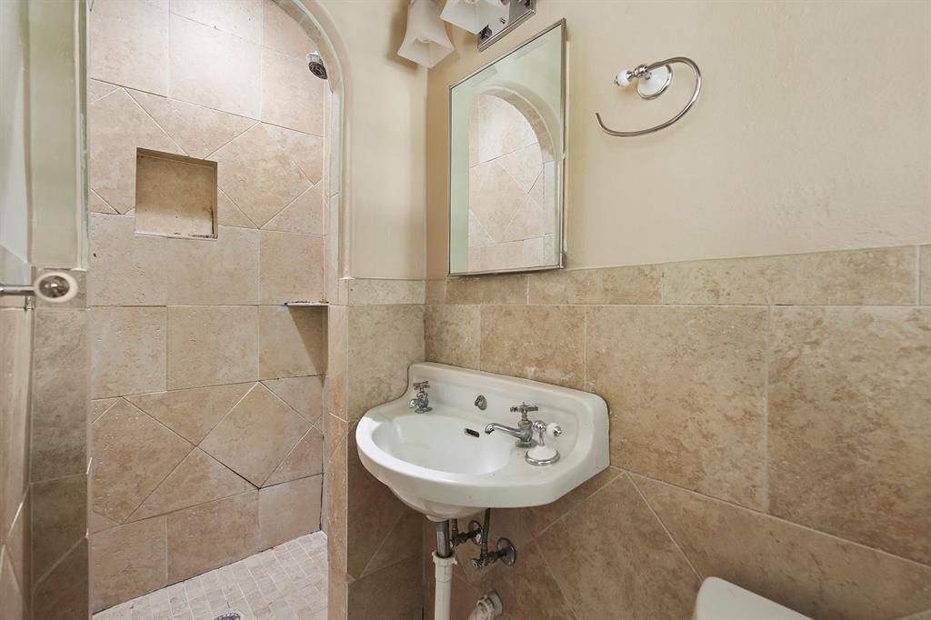 6025 Lewis Street Dallas, TX 75206 - Photo 17 of 37 a bathroom with a sink a mirror and shower