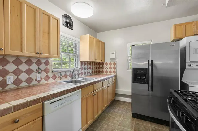 a kitchen with stainless steel appliances a refrigerator sink and wooden cabinets
