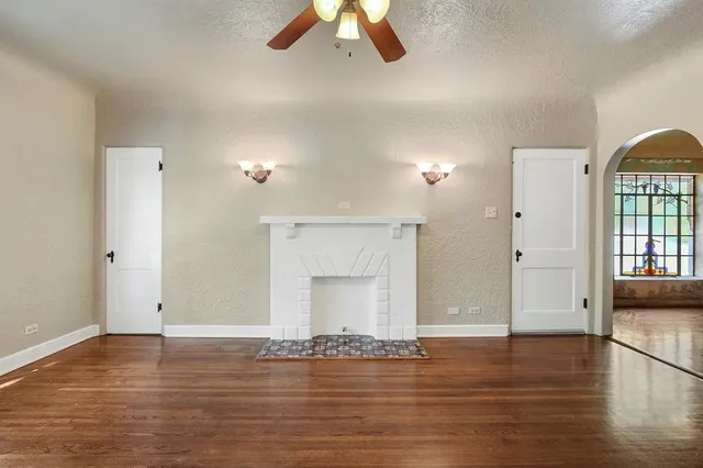 a view of empty room with wooden floor and ceiling fan