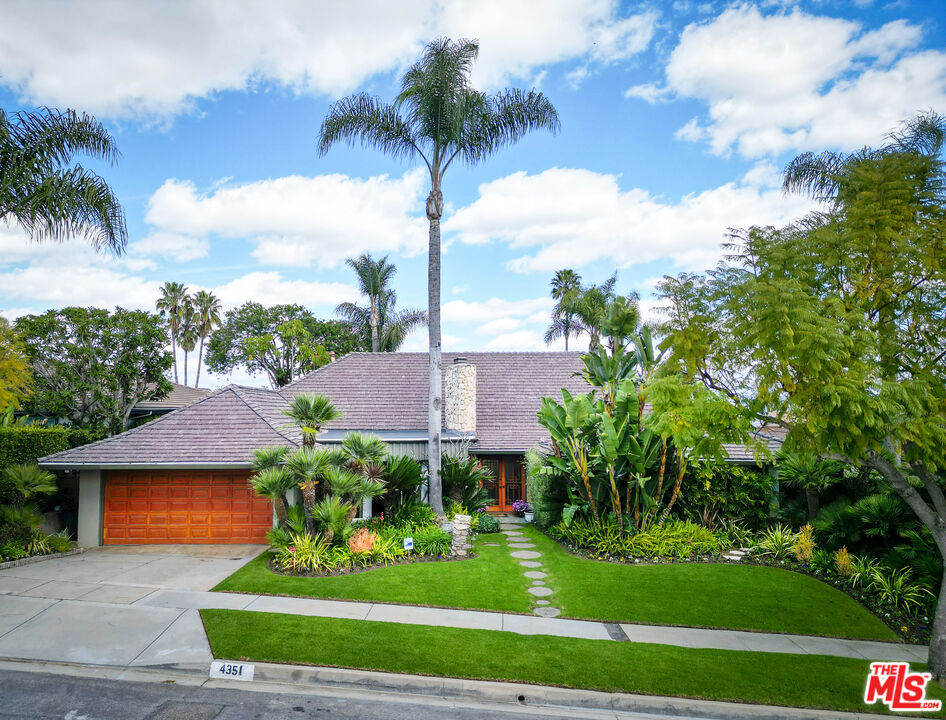 a front view of a house with a garden and yard