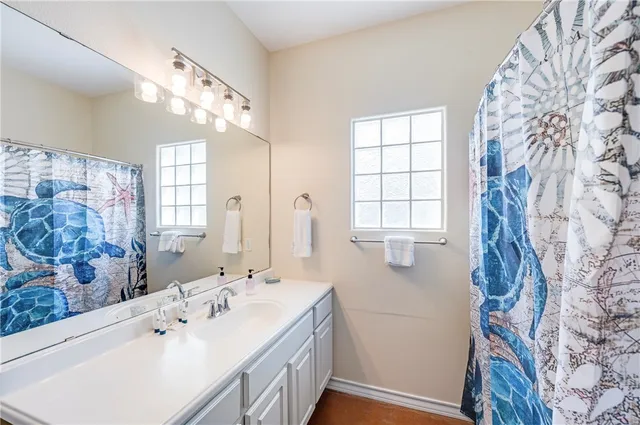 a spacious bathroom with double vanity and a mirror