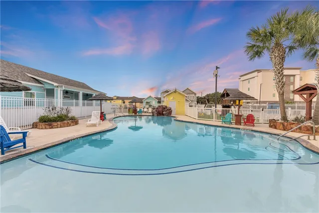 a view of a swimming pool with a chairs and tables in the patio