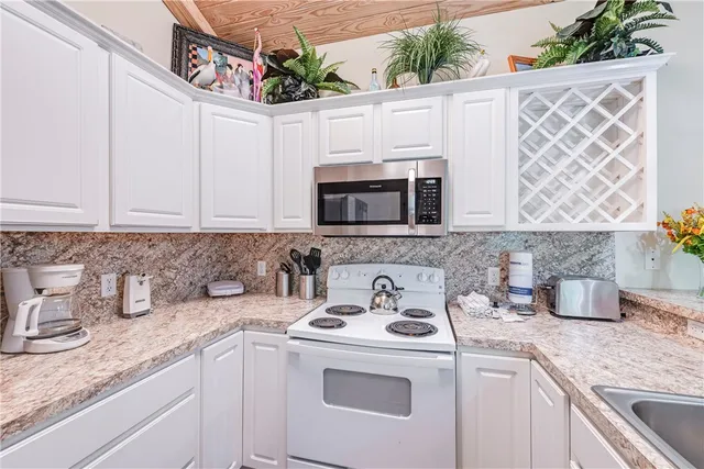 a kitchen with stainless steel appliances granite countertop a sink and a microwave