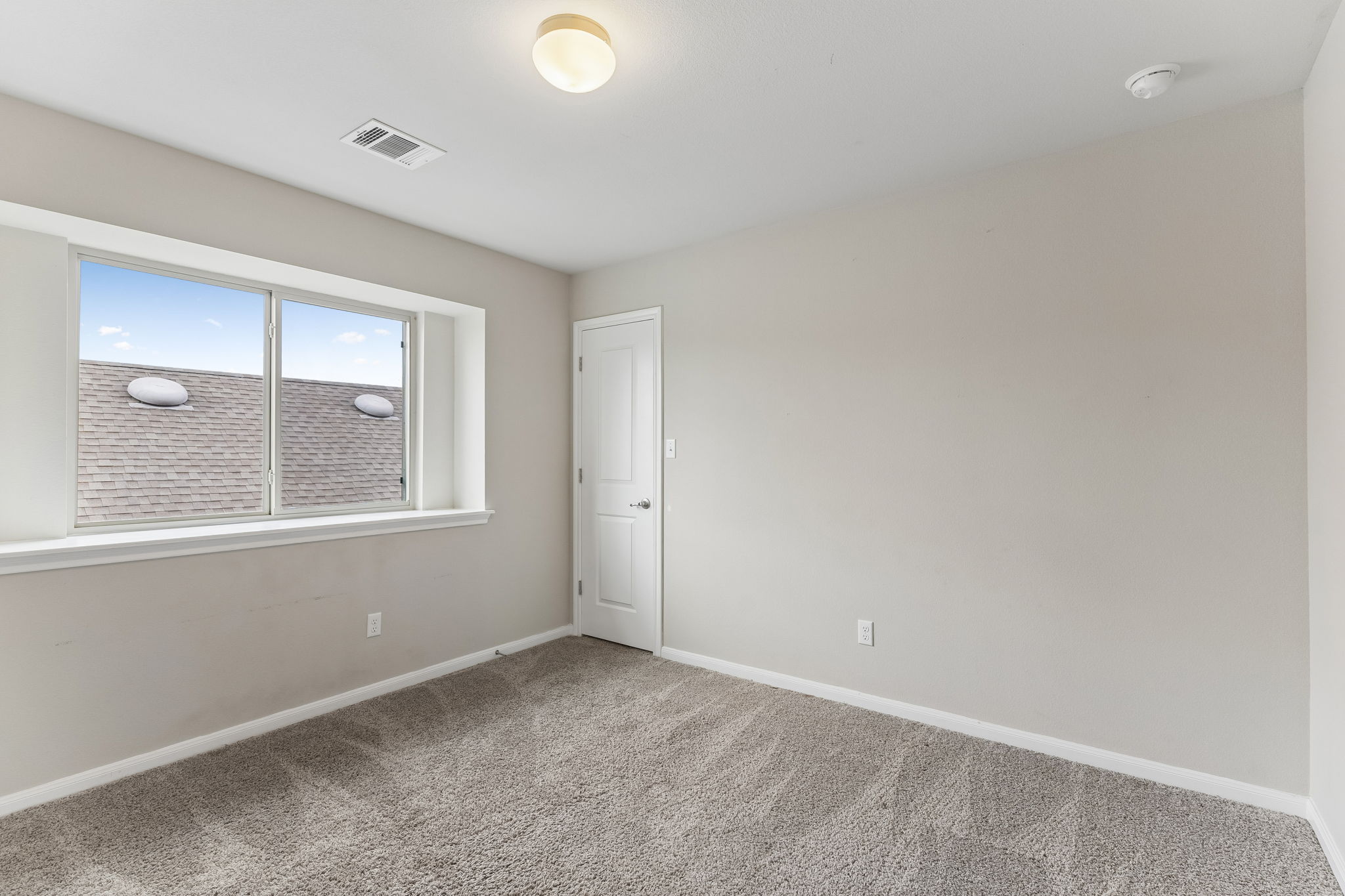 301 Rimrock Court Bastrop, TX 78602 - Photo 17 of 21 Well-lit room with ample natural light, featuring plush carpeting and a clean, neutral palette.