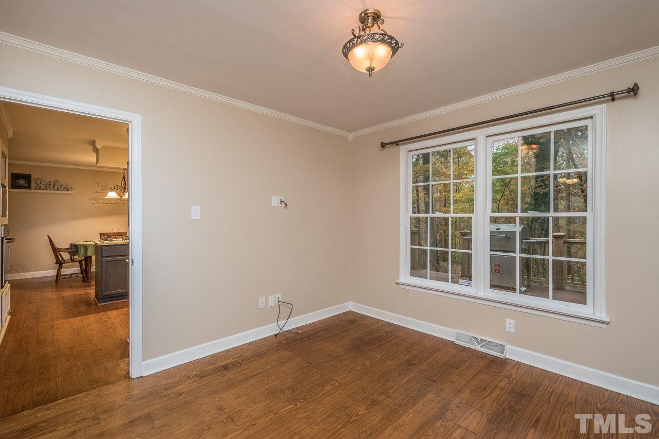 12217 Norwood Road Raleigh, NC 27613 - Photo 14 of 27 an empty room with wooden floor and windows