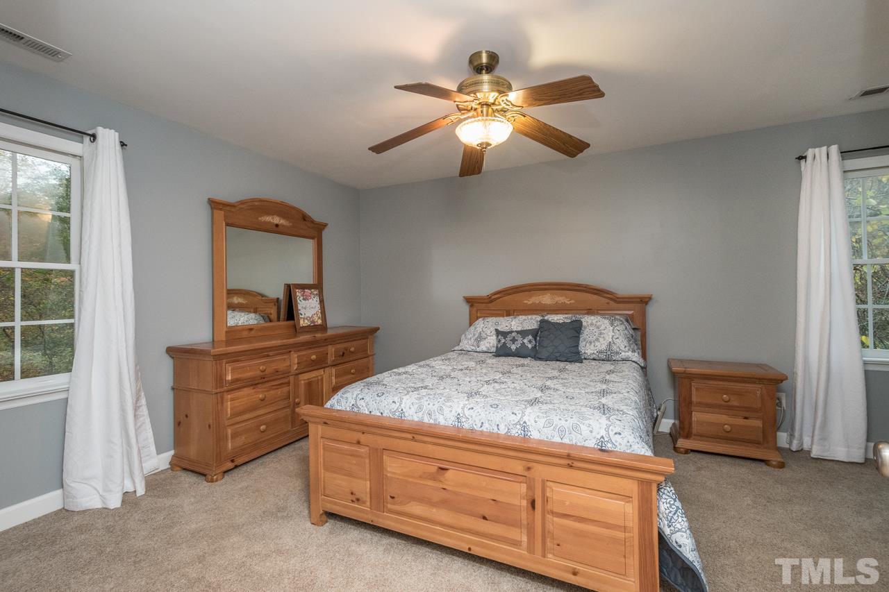 12217 Norwood Road Raleigh, NC 27613 - Photo 15 of 27 a bedroom with a bed and a dresser