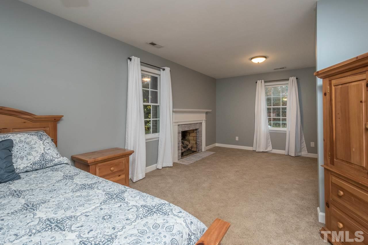 12217 Norwood Road Raleigh, NC 27613 - Photo 16 of 27 a bed room with a bed and a fireplace