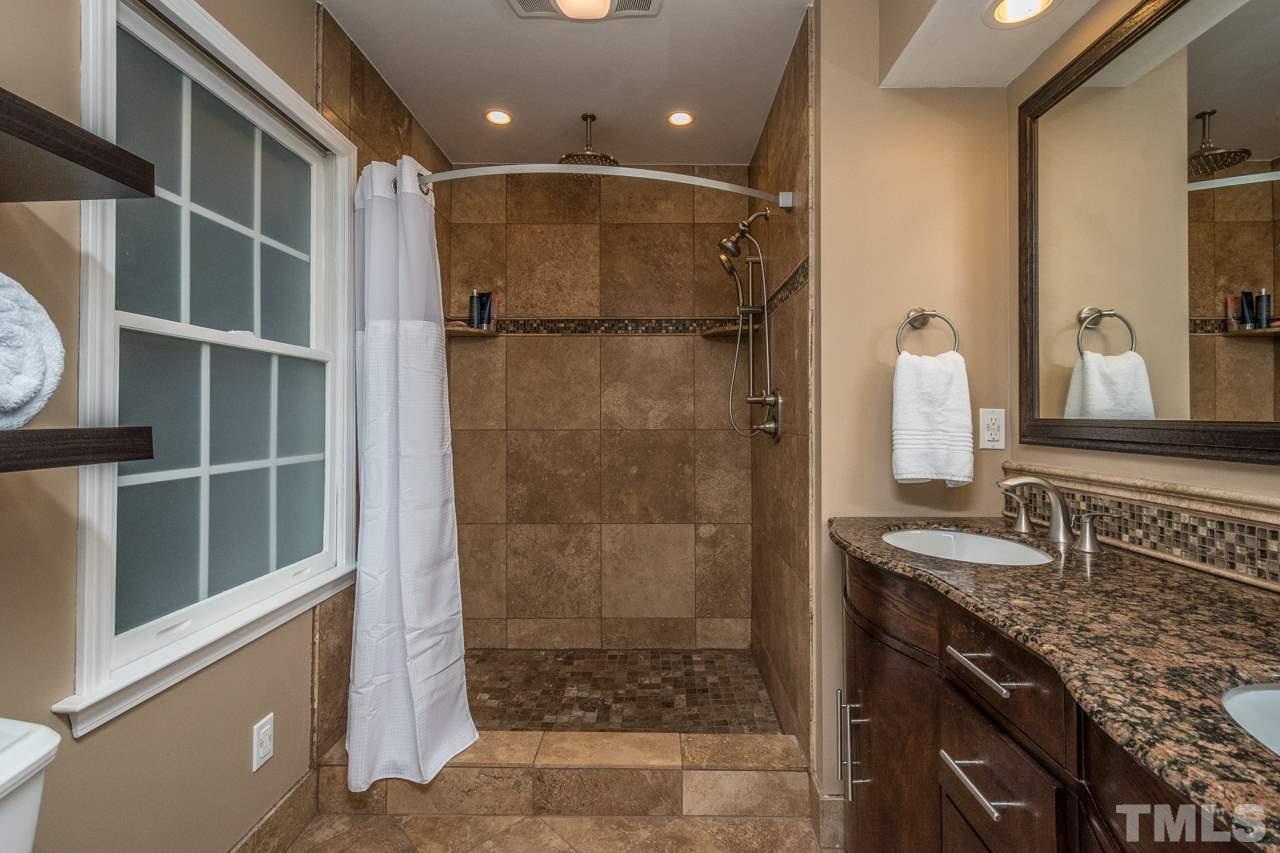 12217 Norwood Road Raleigh, NC 27613 - Photo 18 of 27 a bathroom with a granite countertop sink a toilet and shower
