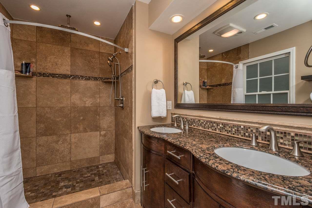 12217 Norwood Road Raleigh, NC 27613 - Photo 19 of 27 a bathroom with a sink double vanity and a shower