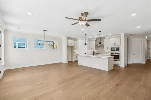 a view of a kitchen with kitchen island a sink stainless steel appliances and cabinets
