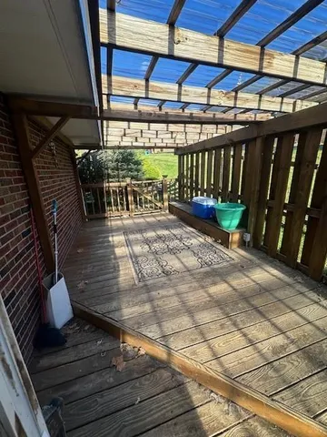a view of an empty room with wooden floor and fan