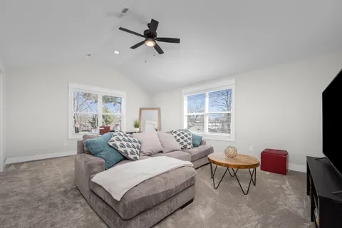 a living room with furniture and a ceiling fan
