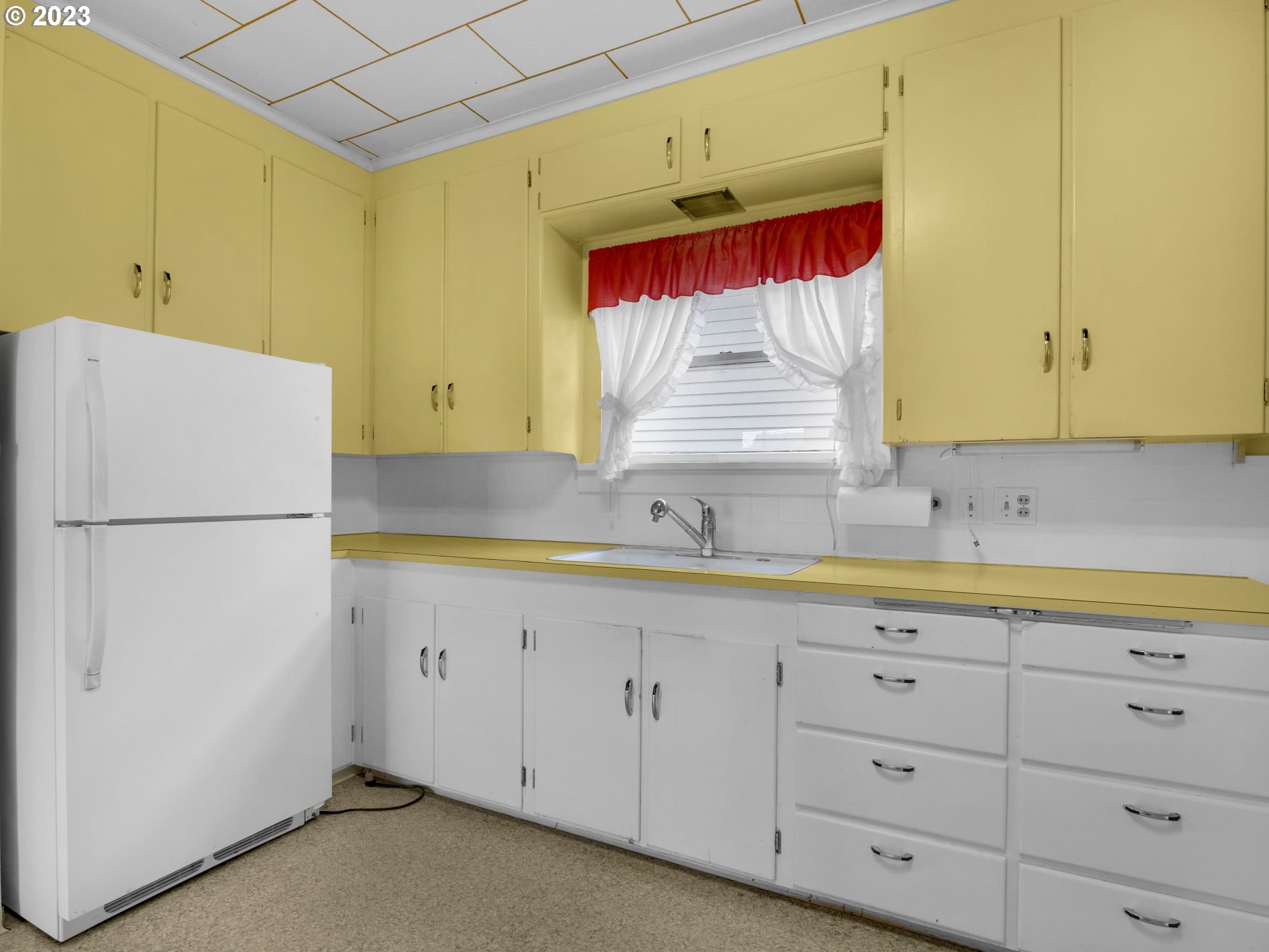 192 West Exchange Street Astoria, OR 97103 - Photo 7 of 34 a kitchen with cabinets a sink and a refrigerator