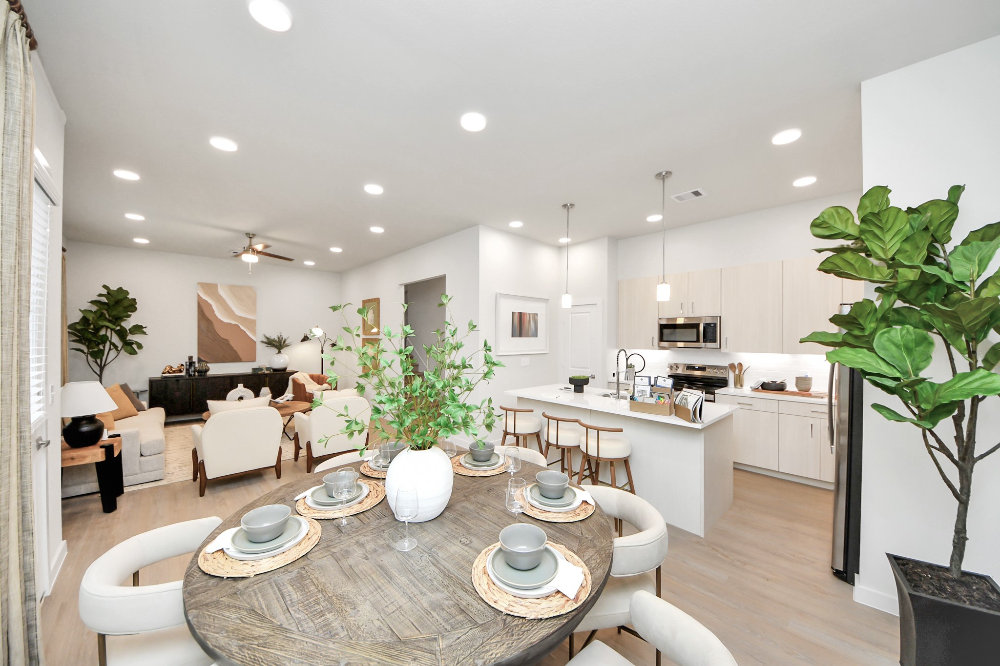 7306 Corey Rushing Lane Richmond, TX 77407 - Photo 6 of 50 a kitchen with stainless steel appliances kitchen island granite countertop a stove a dining table and chairs with wooden floor