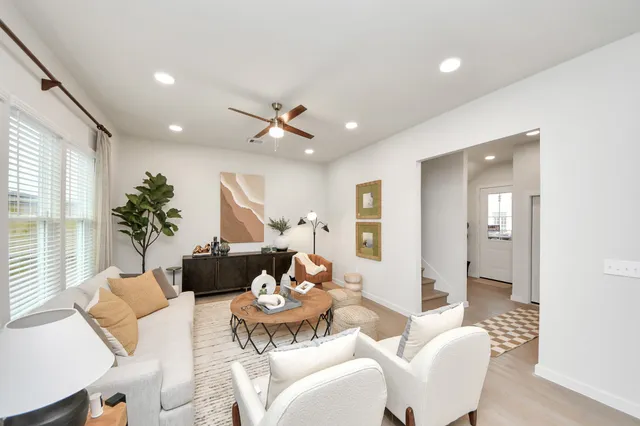 a kitchen with stainless steel appliances a dining table chairs refrigerator and microwave