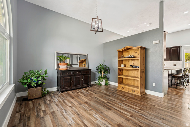 332 East Magellan Lane Elk Ridge, UT 84651 - Photo 5 of 24 Spacious interior room featuring wood-finish flooring, vaulted ceilings, a large window, and a contemporary hanging light fixture