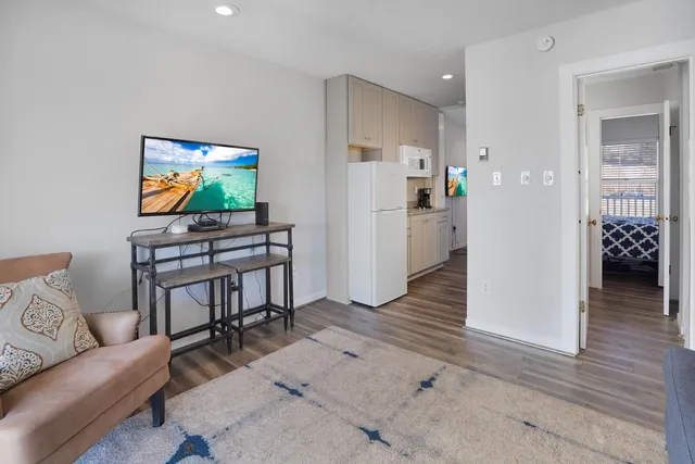 a living room with furniture and a wooden floor