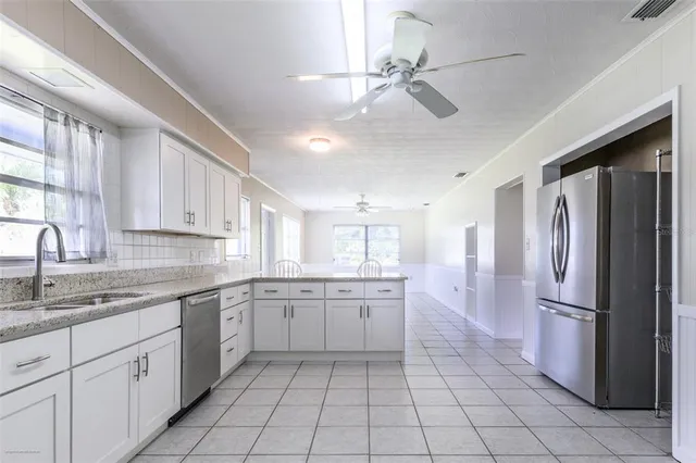 a kitchen with a refrigerator sink and cabinets