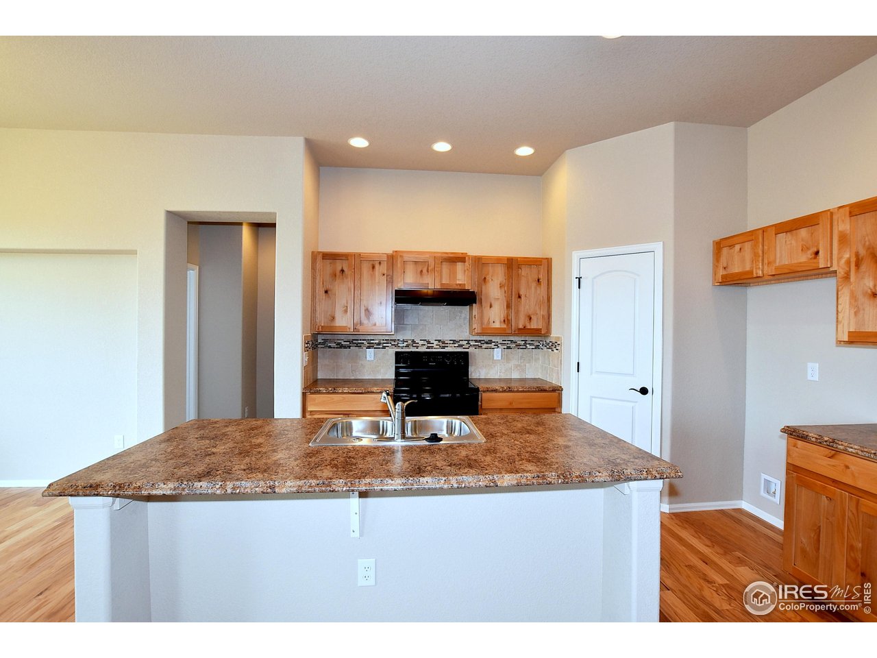623 86th Avenue Greeley, CO 80634 - Photo 16 of 38 a kitchen with kitchen island granite countertop a refrigerator a stove and a sink