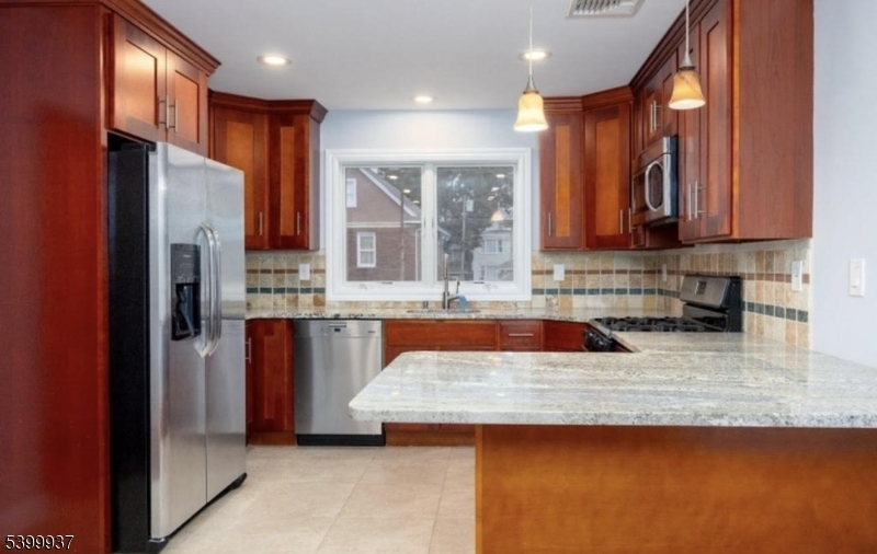 71 Christie Avenue, Unit 2 Clifton, NJ 07011 - Photo 2 of 8 a kitchen with stainless steel appliances granite countertop a refrigerator a stove and a sink