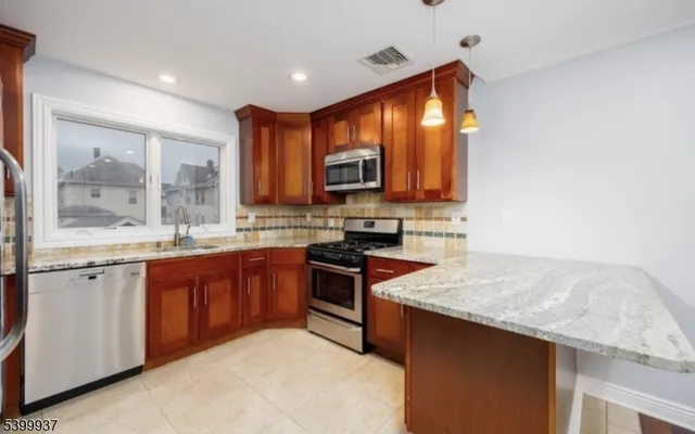 a kitchen with stainless steel appliances granite countertop a stove a sink and a microwave