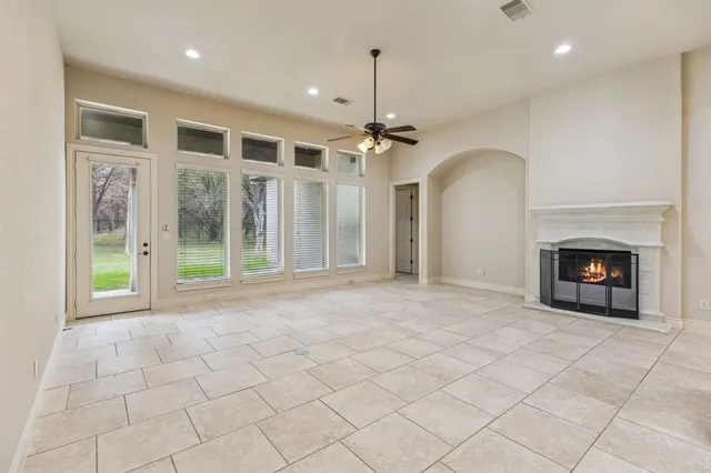 a view of an empty room with a fireplace and a chandelier