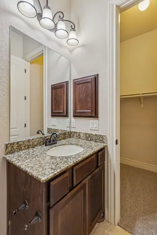 a bathroom with a granite countertop sink and a mirror