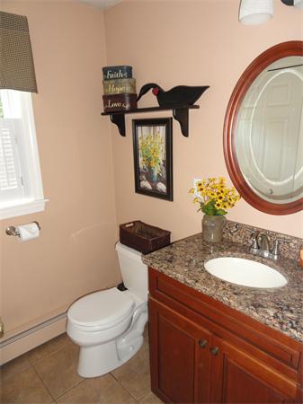 98 Bushy Lane Rutland, MA 01543 - Photo 22 of 30 a bathroom with a granite countertop toilet a sink and a mirror