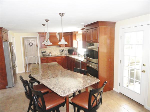 98 Bushy Lane Rutland, MA 01543 - Photo 3 of 30 a kitchen with granite countertop a refrigerator a stove a sink a dining table and chairs