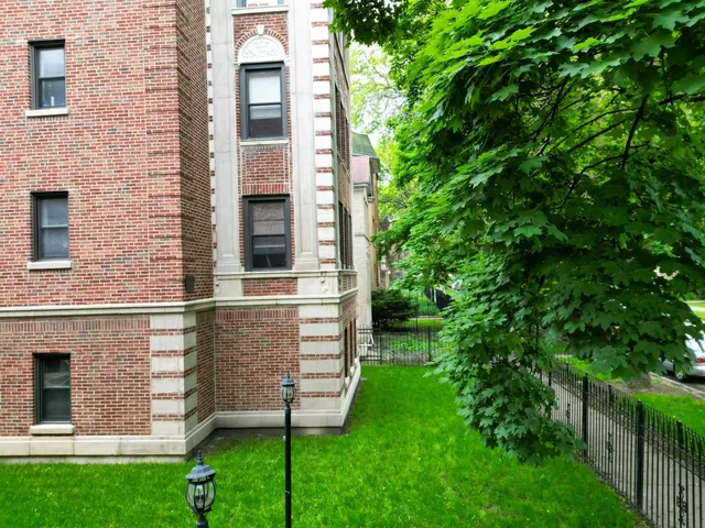 a view of a brick house with a large window and a large tree