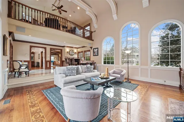 a living room with furniture a large window and wooden floor