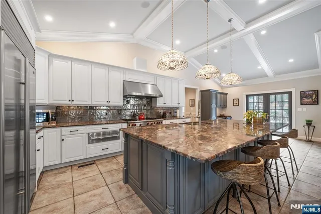 a kitchen with kitchen island granite countertop a sink center island and cabinets