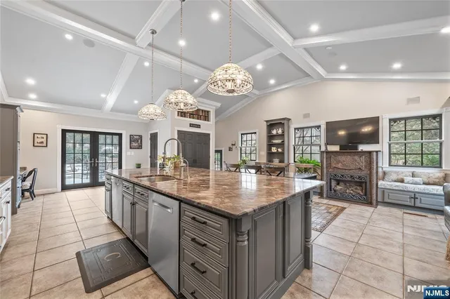 a large kitchen with a counter space a sink appliances and living room view