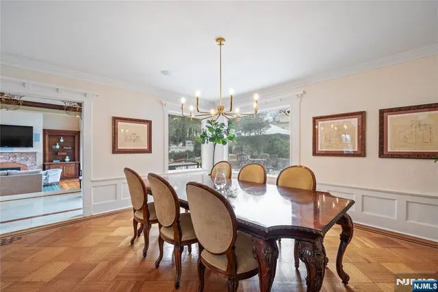 a dining room with furniture a chandelier and wooden floor