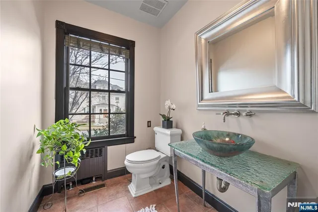 a bathroom with a granite countertop toilet sink and mirror