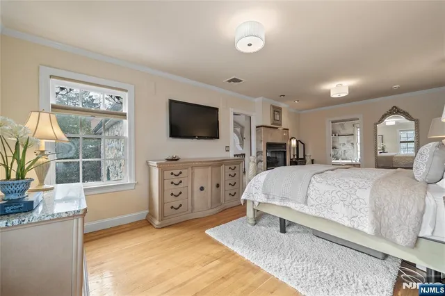 a bedroom with a large bed and a flat tv screen on dresser