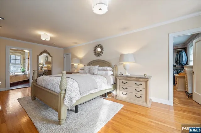 a bedroom with a large bed and a chandelier