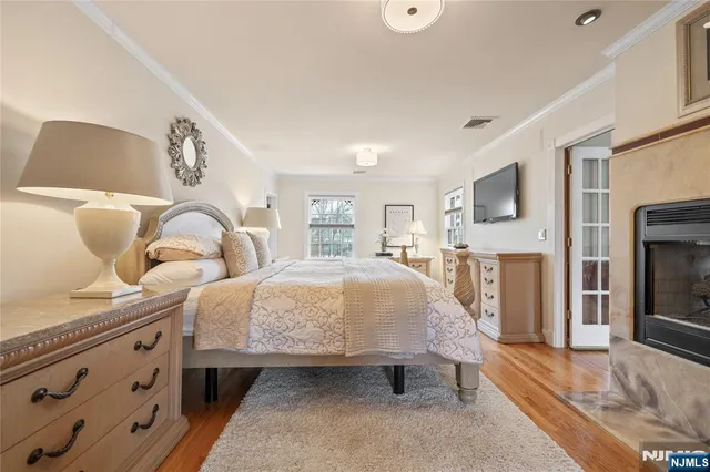 a bedroom with bed and flat tv screen on dresser