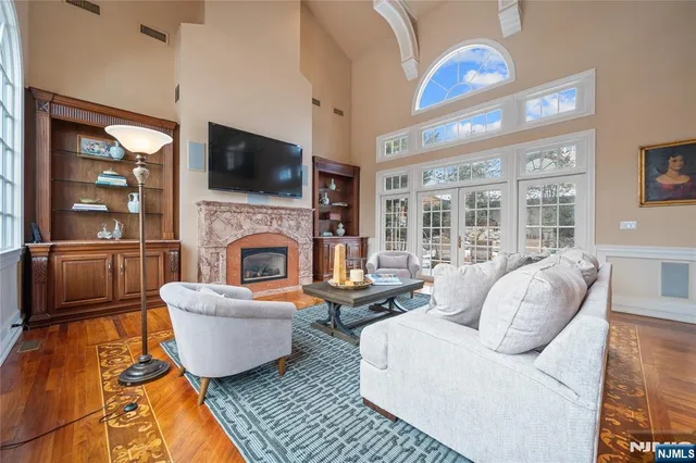 a living room with furniture a large window and wooden floor
