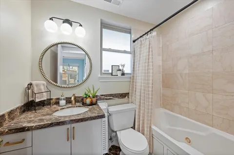 a bathroom with a granite countertop toilet a sink and a mirror