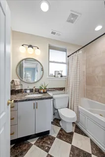 a bathroom with a granite countertop toilet a sink and a mirror