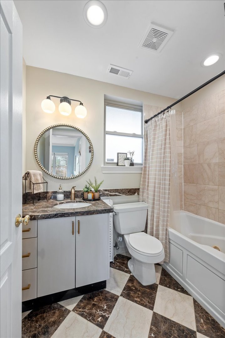 3135 West Palmer Square, Unit 3 Chicago, IL 60647 - Photo 22 of 30 a bathroom with a granite countertop toilet a sink and a mirror