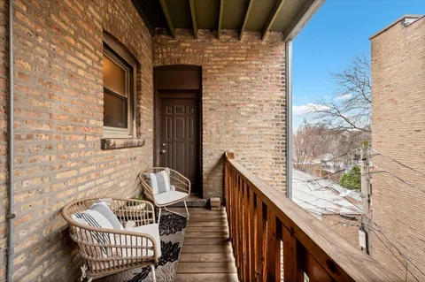 a balcony with wooden floor and outdoor seating
