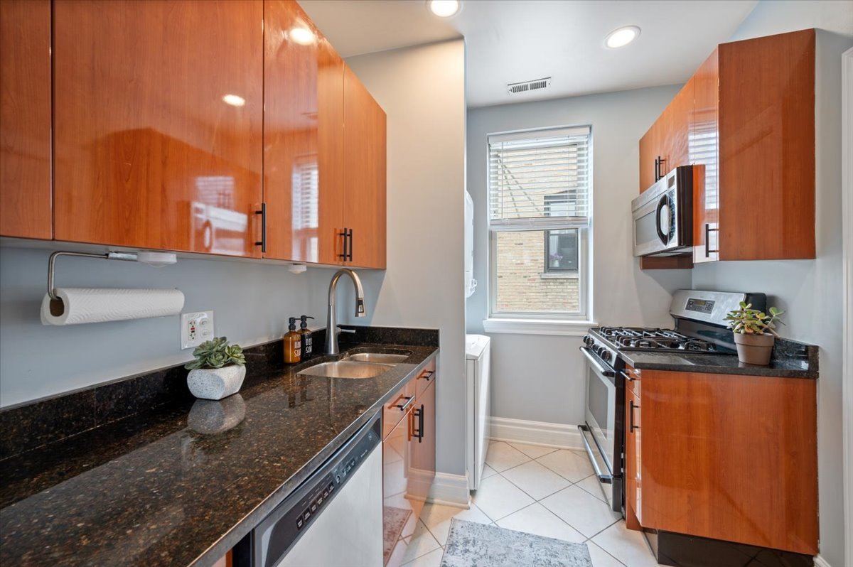 3135 West Palmer Square, Unit 3 Chicago, IL 60647 - Photo 9 of 30 a kitchen with stainless steel appliances granite countertop a sink a stove and a wooden floors