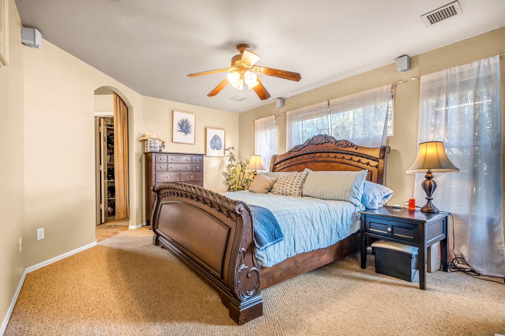 697 Jasper Drive Fruita, CO 81521 - Photo 12 of 26 a spacious bedroom with a bed and a chandelier