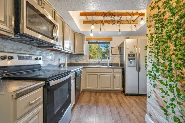 a kitchen with stainless steel appliances granite countertop a stove and a wooden cabinets