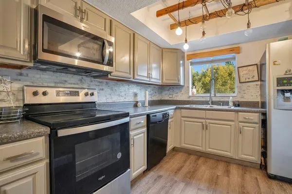 a kitchen with stainless steel appliances granite countertop wooden cabinets stove top oven and sink