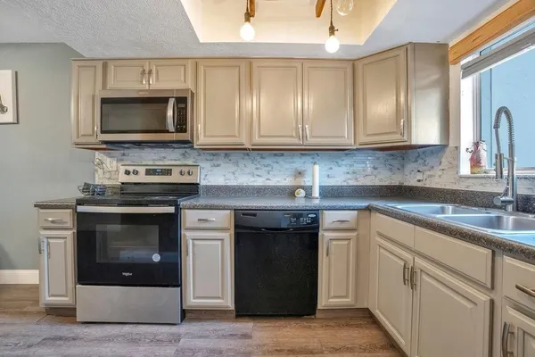 a kitchen with white cabinets and stainless steel appliances